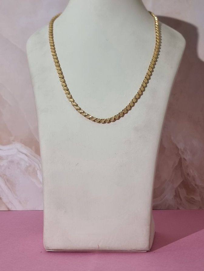 The phone photo it came from: the same chain on a bust with a pink backdrop